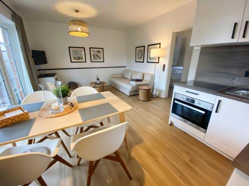 a kitchen and living room with a table and chairs at Steilufer Appartments in Timmendorfer Strand