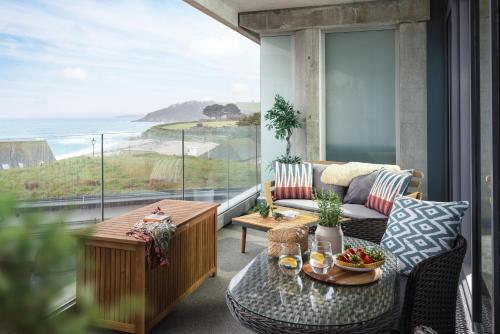 a balcony with a couch and a table and a view of the ocean at St Michaels The Liner in Falmouth