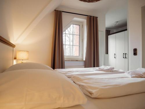 two beds in a room with a window at Steilufer Appartments in Timmendorfer Strand