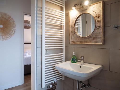 a bathroom with a sink and a mirror at Steilufer Appartments in Timmendorfer Strand