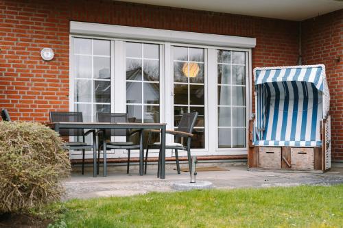 a patio with a table and chairs on a house at Steilufer Appartments in Timmendorfer Strand