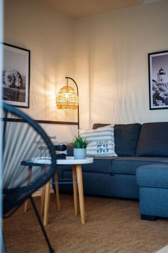 a living room with a blue couch and a table at Steilufer Appartments in Timmendorfer Strand
