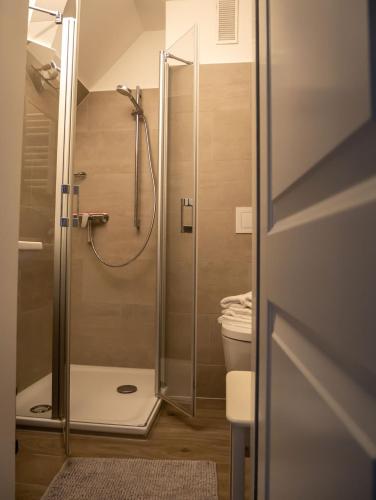 a shower with a glass door in a bathroom at Steilufer Appartments in Timmendorfer Strand