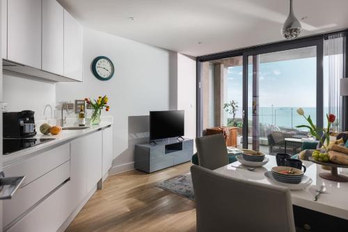 a kitchen and living room with a table and a television at St Michaels The Liner in Falmouth