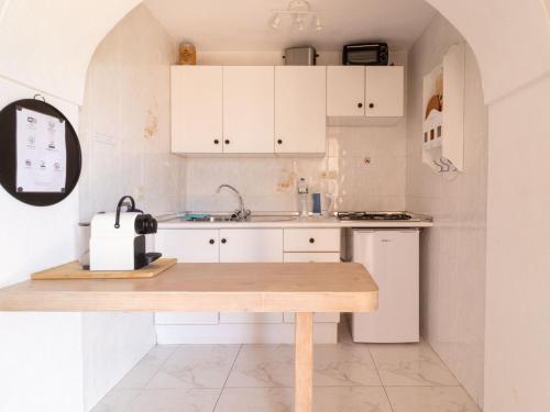 een keuken met witte kasten en een houten tafel bij La Casa del Burro in Nerja