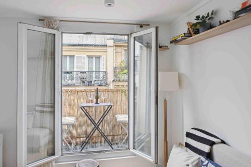 Cette chambre dispose d'une porte coulissante en verre s'ouvrant sur un balcon. dans l'établissement Le Trésor, à Paris