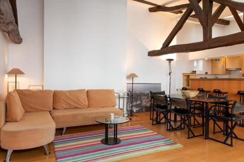 un salon avec un canapé et une table dans l'établissement Orange Vendome - Bright 1-Bed Apt Near the Louvre, à Paris
