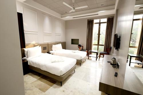 Hotel Statusinn, Ichalkaranjiにあるベッド