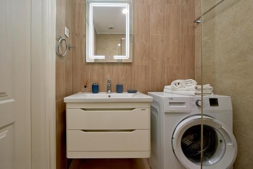 a bathroom with a washing machine and a sink at Skyline resort in Bečići