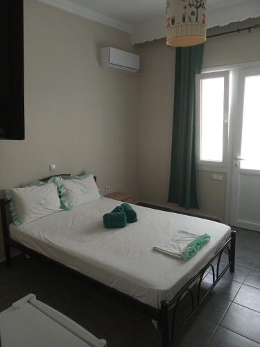 ein Bett in einem Zimmer mit Fenster in der Unterkunft Iordanis in Néa Karváli