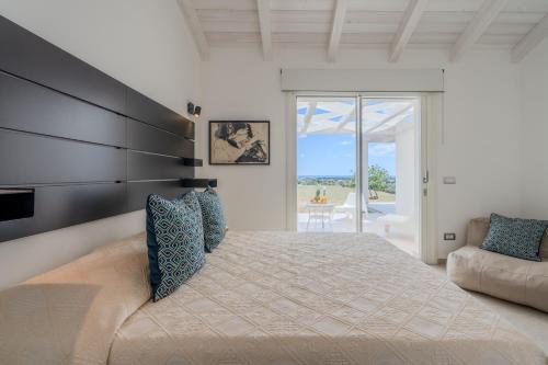 a bedroom with a large bed and a couch at Villa DEG Vista Mare San Teodoro Puntaldia in San Teodoro