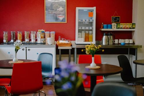 a restaurant with tables and chairs and a red wall at Pitlochry Youth Hostel in Pitlochry