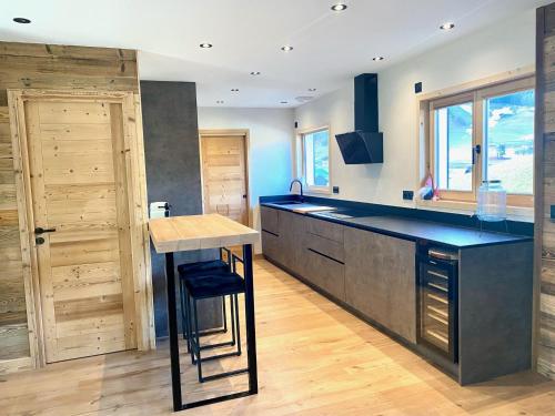 a kitchen with a black counter and a wooden door at Chalet rénové, 10 personnes, 5 chambres - CH14 in Beaufort