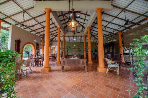 a lobby with tables and chairs and a chandelier at Ging Oya Lodge in Waikkal