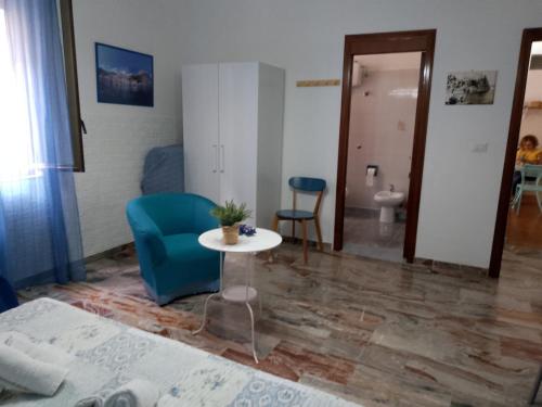 a living room with a table and a blue chair at Scilla A Vinedda in Scilla