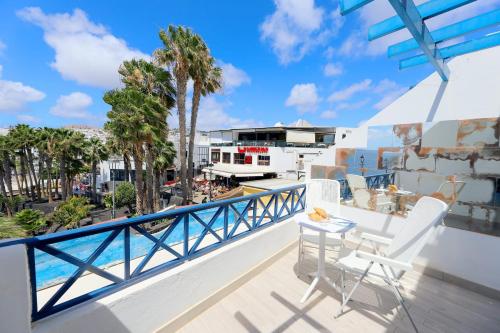 a balcony with a table and chairs and a view of the ocean at Lanzarote Apartment Rental Harbour View in Tías