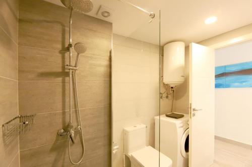 a bathroom with a toilet and a glass shower at Lanzarote Apartment Rental Harbour View in Tías