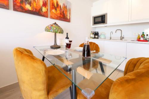 a dining room with a glass table and chairs at Lanzarote Apartment Rental Harbour View in Tías