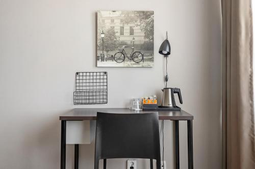 a desk with a chair and a picture of a bike on the wall at Best Western Plus Park Airport Hotel in Arlanda