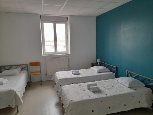 a room with three beds and a window at Centre Louis Ormières in Montauban