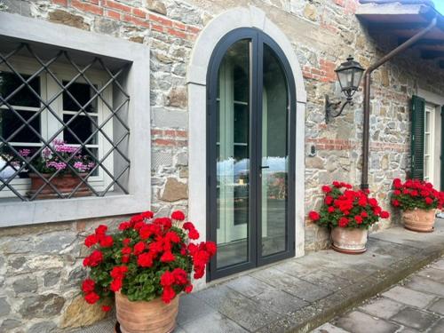 three pots of red flowers on the side of a building at Appartamento in villa - Maria Grazia in Scarperia