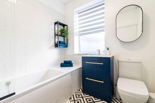 a bathroom with a tub and a toilet and a sink at Glasswing Stays Margaret st, central Sheffield in Sheffield