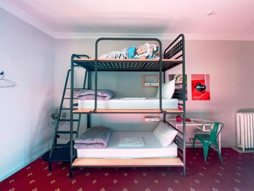 a room with three bunk beds in a room at Ostello Bello Roma Colosseo in Rome