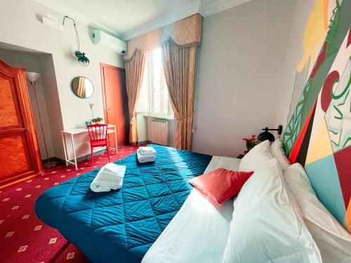 a hotel room with a bed with a blue blanket at Ostello Bello Roma Colosseo in Rome