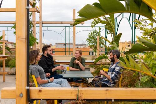 a group of people sitting around a table on a roof at Ostello Bello Roma Colosseo in Rome
