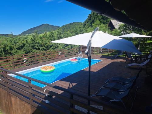 an umbrella and chairs next to a swimming pool at Kuća za odmor MARE in Lepoglava