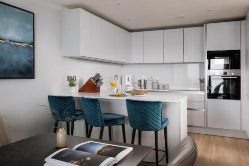 a kitchen with white cabinets and a table and chairs at St Michaels The Liner in Falmouth