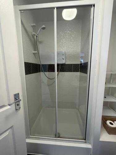 a shower with a glass door in a bathroom at Cosy two bedrooms flat suitable for a short trip in Portsmouth