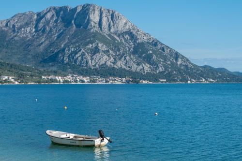 a boat in the water with a mountain in the background at Villa Laganini Apartment 2&4 in Podaca
