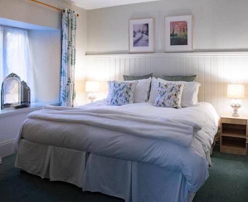 une chambre avec un grand lit avec des oreillers dans l'établissement The Rookery Cottage - Newland, à Newland