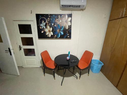 a table and four chairs in a room at Villa de chez nous in North Legon