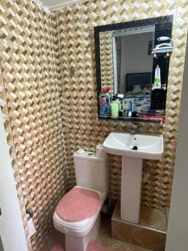a bathroom with a sink and a toilet and a mirror at Villa de chez nous in North Legon