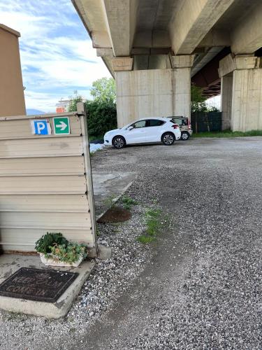 a white car is parked under a bridge at ViaVai Pisa Airport in Pisa