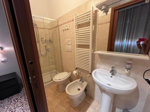 a bathroom with a sink and a toilet and a shower at ViaVai Pisa Airport in Pisa