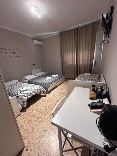 a room with two beds and a table in it at ViaVai Pisa Airport in Pisa