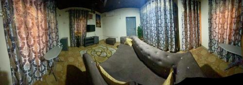 a room with chairs and curtains in a room at Villa de chez nous in North Legon