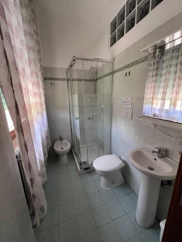 a bathroom with a sink and a toilet and a shower at ViaVai Pisa Airport in Pisa