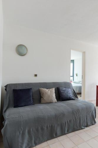 - un canapé gris avec des oreillers dans l'établissement Appartement C 529 piscine front de mer, à Sète