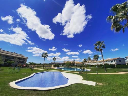 a swimming pool in a park with palm trees at Casa Roberto - Golf y relax in San Jorge