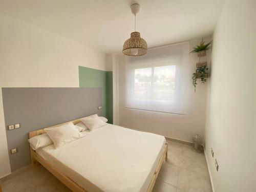 a bedroom with a large white bed with a window at Casa Roberto - Golf y relax in San Jorge