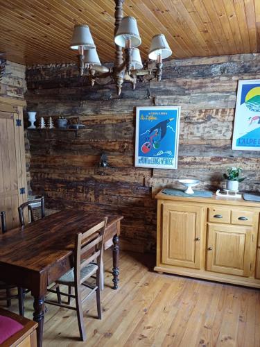 d'une salle à manger avec une table et des murs en bois. dans l'établissement La Cabane des 2 Sœurs (chalet 4-6 personnes), à Les Ougiers