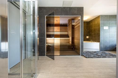 a bathroom with a glass walk in shower and a sink at Mana Suites & Sea in Palanga