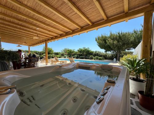 un jacuzzi en un patio junto a una piscina en White Pearl Villa Naxos with Private Swimming Pool, en Naxos Chora