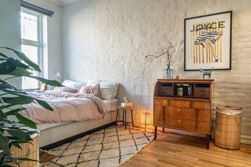 a bedroom with a bed and a wooden dresser at Attraktiv og klassisk leilighet midt i Oslo, 80m2 in Oslo