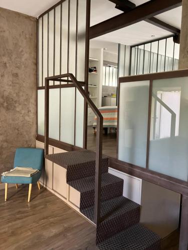 Cette chambre est dotée d'un escalier et d'une chaise bleue. dans l'établissement Loft dans le centre-ville de Hyères, à Hyères