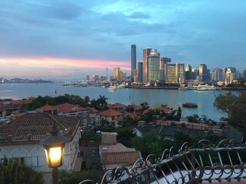 Una vista del horizonte de una ciudad con una farola en 厦门鼓浪屿船屋老别墅旅馆, en Xiamen